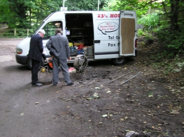 ABC van with its doors open on a roadside job, two men working